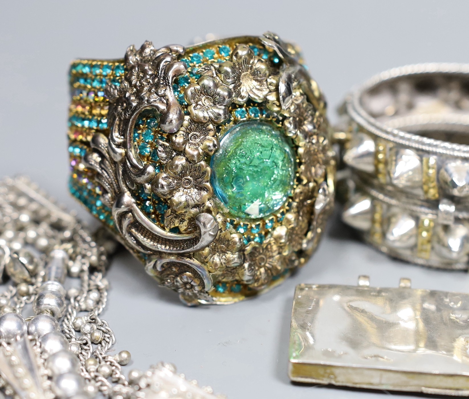 A small group of Middle Eastern mainly white metal jewellery, including bangles, bracelets and an Omani Hirz necklace.
